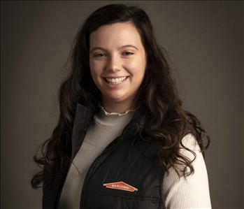 female servpro employee wearing vest in front of blank background